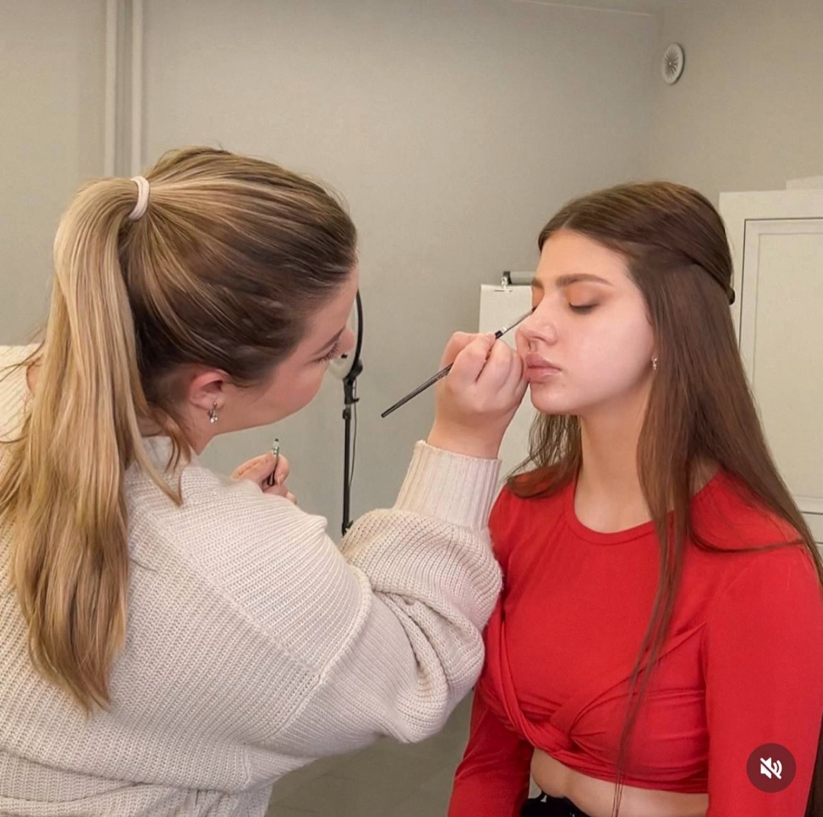 Elizaveta applying makeup to a client